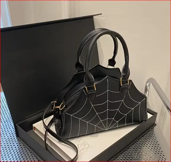 Black handbag with a spider web pattern and detachable strap